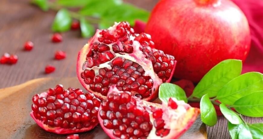 Natur markalı taze ve kaliteli narların şifalı sırları, kesilmiş nar taneleri ve bütün kırmızı nar.